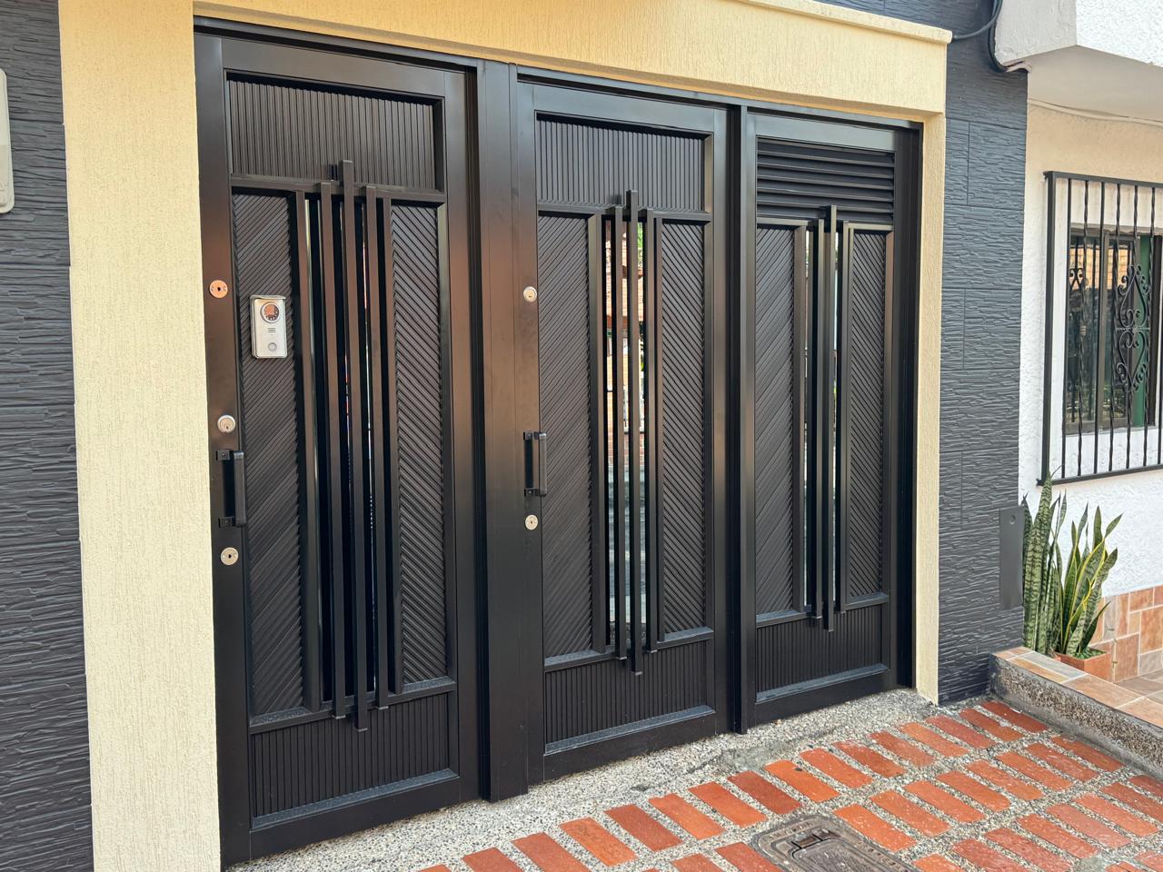Portón triple negro para entrada de casa con citofonía en Medellín